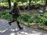 Indian Army, JK Police, and CRPF personnel rush towards the site where an encounter breaks out between security forces and militants at Chec...