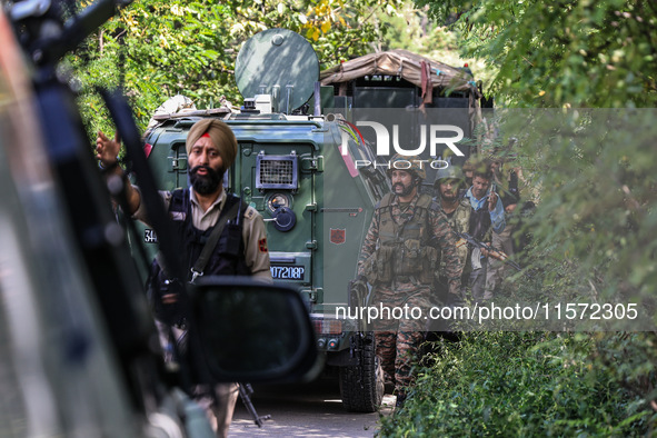 Indian Army, JK Police, and CRPF personnel rush towards the site where an encounter breaks out between security forces and militants at Chec...