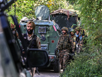 Indian Army, JK Police, and CRPF personnel rush towards the site where an encounter breaks out between security forces and militants at Chec...