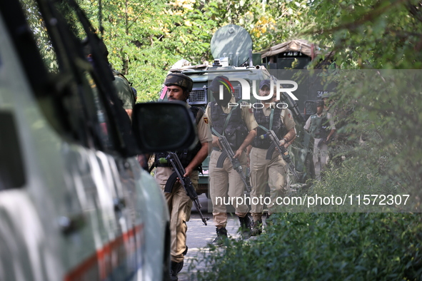 Indian Army, JK Police, and CRPF personnel rush towards the site where an encounter breaks out between security forces and militants at Chec...