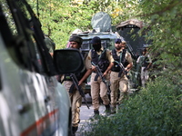 Indian Army, JK Police, and CRPF personnel rush towards the site where an encounter breaks out between security forces and militants at Chec...