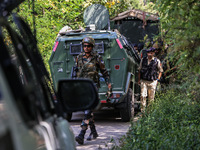 Indian Army, JK Police, and CRPF personnel rush towards the site where an encounter breaks out between security forces and militants at Chec...