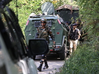 Indian Army, JK Police, and CRPF personnel rush towards the site where an encounter breaks out between security forces and militants at Chec...