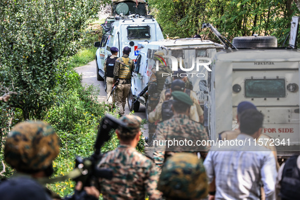 Indian security officials move towards an encounter site between militants and security forces in Check Kreeri Tapper in Baramulla, Jammu an...