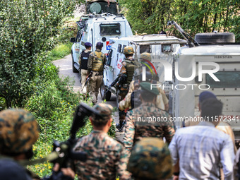 Indian security officials move towards an encounter site between militants and security forces in Check Kreeri Tapper in Baramulla, Jammu an...