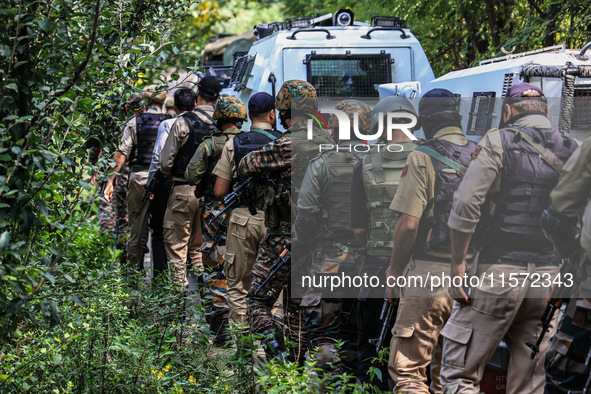 Indian security officials move towards an encounter site between militants and security forces in Check Kreeri Tapper in Baramulla, Jammu an...