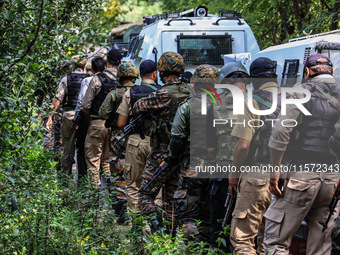 Indian security officials move towards an encounter site between militants and security forces in Check Kreeri Tapper in Baramulla, Jammu an...