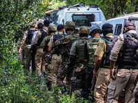 Indian security officials move towards an encounter site between militants and security forces in Check Kreeri Tapper in Baramulla, Jammu an...