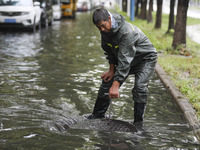 A municipal worker removes flood water after heavy rains in Huai'an, China, on September 14, 2024. (