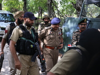 Indian security officials move towards an encounter site between militants and security forces in Check Kreeri Tapper in Baramulla, Jammu an...