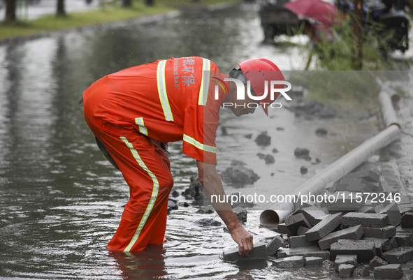 A municipal worker removes flood water after heavy rains in Huai'an, China, on September 14, 2024. 