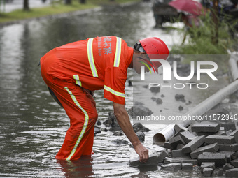 A municipal worker removes flood water after heavy rains in Huai'an, China, on September 14, 2024. (