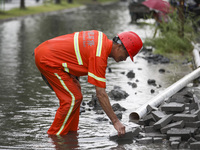 A municipal worker removes flood water after heavy rains in Huai'an, China, on September 14, 2024. (