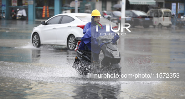 People travel in the rain in Huai'an, China, on September 14, 2024. 