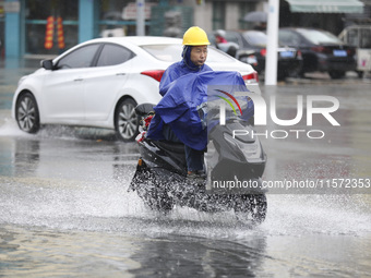 People travel in the rain in Huai'an, China, on September 14, 2024. (