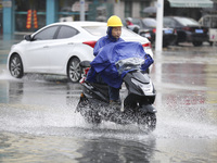 People travel in the rain in Huai'an, China, on September 14, 2024. (