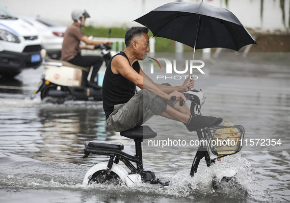 People travel in the rain in Huai'an, China, on September 14, 2024. 