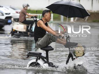 People travel in the rain in Huai'an, China, on September 14, 2024. (