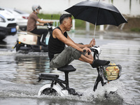 People travel in the rain in Huai'an, China, on September 14, 2024. (