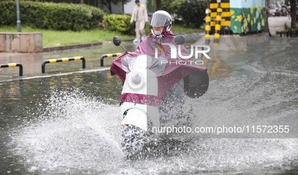 People travel in the rain in Huai'an, China, on September 14, 2024. 