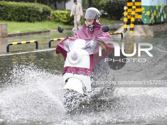 People travel in the rain in Huai'an, China, on September 14, 2024. (