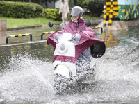 People travel in the rain in Huai'an, China, on September 14, 2024. (