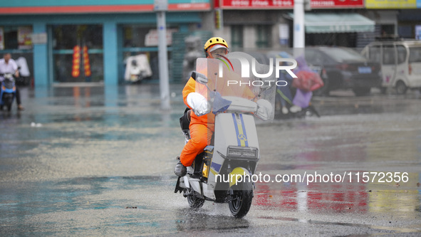 People travel in the rain in Huai'an, China, on September 14, 2024. 