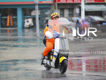 People travel in the rain in Huai'an, China, on September 14, 2024. (