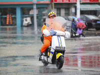 People travel in the rain in Huai'an, China, on September 14, 2024. (