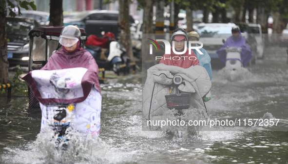 People travel in the rain in Huai'an, China, on September 14, 2024. 