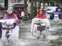 People travel in the rain in Huai'an, China, on September 14, 2024. (