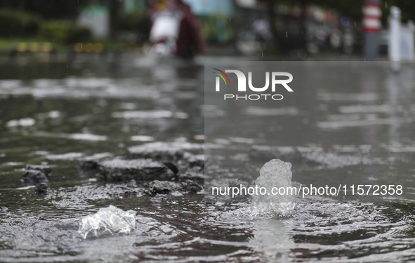 People travel in the rain in Huai'an, China, on September 14, 2024. 