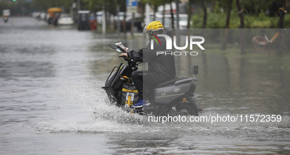 People travel in the rain in Huai'an, China, on September 14, 2024. 