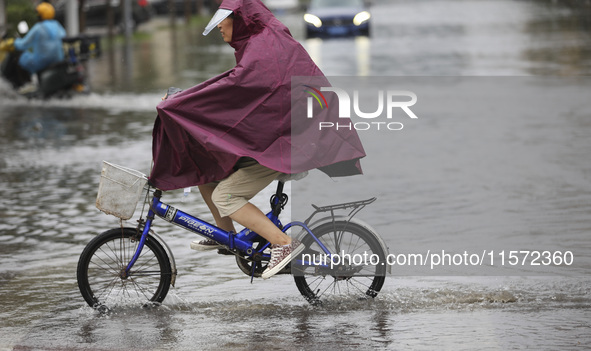 People travel in the rain in Huai'an, China, on September 14, 2024. 