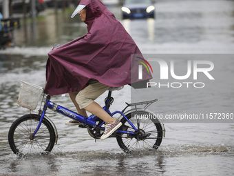 People travel in the rain in Huai'an, China, on September 14, 2024. (