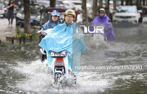 People travel in the rain in Huai'an, China, on September 14, 2024. 