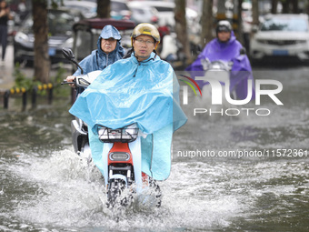 People travel in the rain in Huai'an, China, on September 14, 2024. (