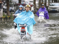 People travel in the rain in Huai'an, China, on September 14, 2024. (