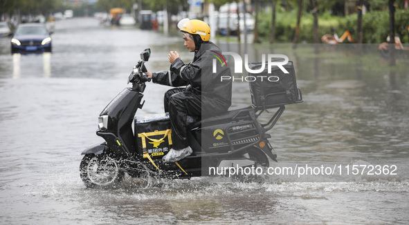 People travel in the rain in Huai'an, China, on September 14, 2024. 