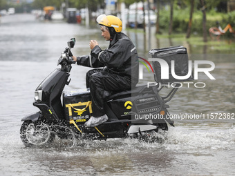 People travel in the rain in Huai'an, China, on September 14, 2024. (