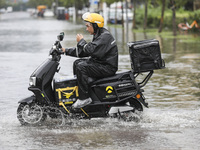 People travel in the rain in Huai'an, China, on September 14, 2024. (