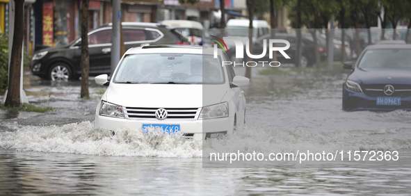 People travel in the rain in Huai'an, China, on September 14, 2024. 