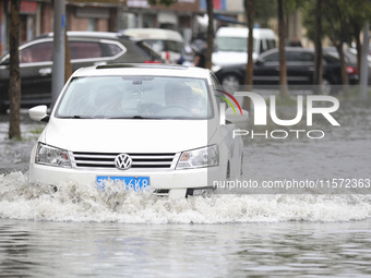 People travel in the rain in Huai'an, China, on September 14, 2024. (