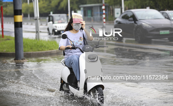 People travel in the rain in Huai'an, China, on September 14, 2024. 