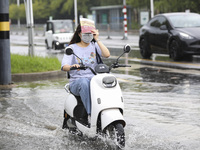 People travel in the rain in Huai'an, China, on September 14, 2024. (