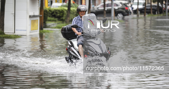 People travel in the rain in Huai'an, China, on September 14, 2024. 