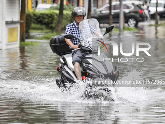 People travel in the rain in Huai'an, China, on September 14, 2024. (