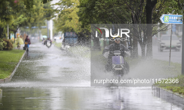 People travel in the rain in Huai'an, China, on September 14, 2024. 