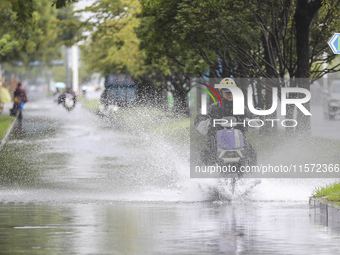 People travel in the rain in Huai'an, China, on September 14, 2024. (