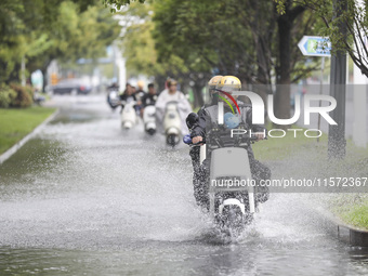 People travel in the rain in Huai'an, China, on September 14, 2024. (